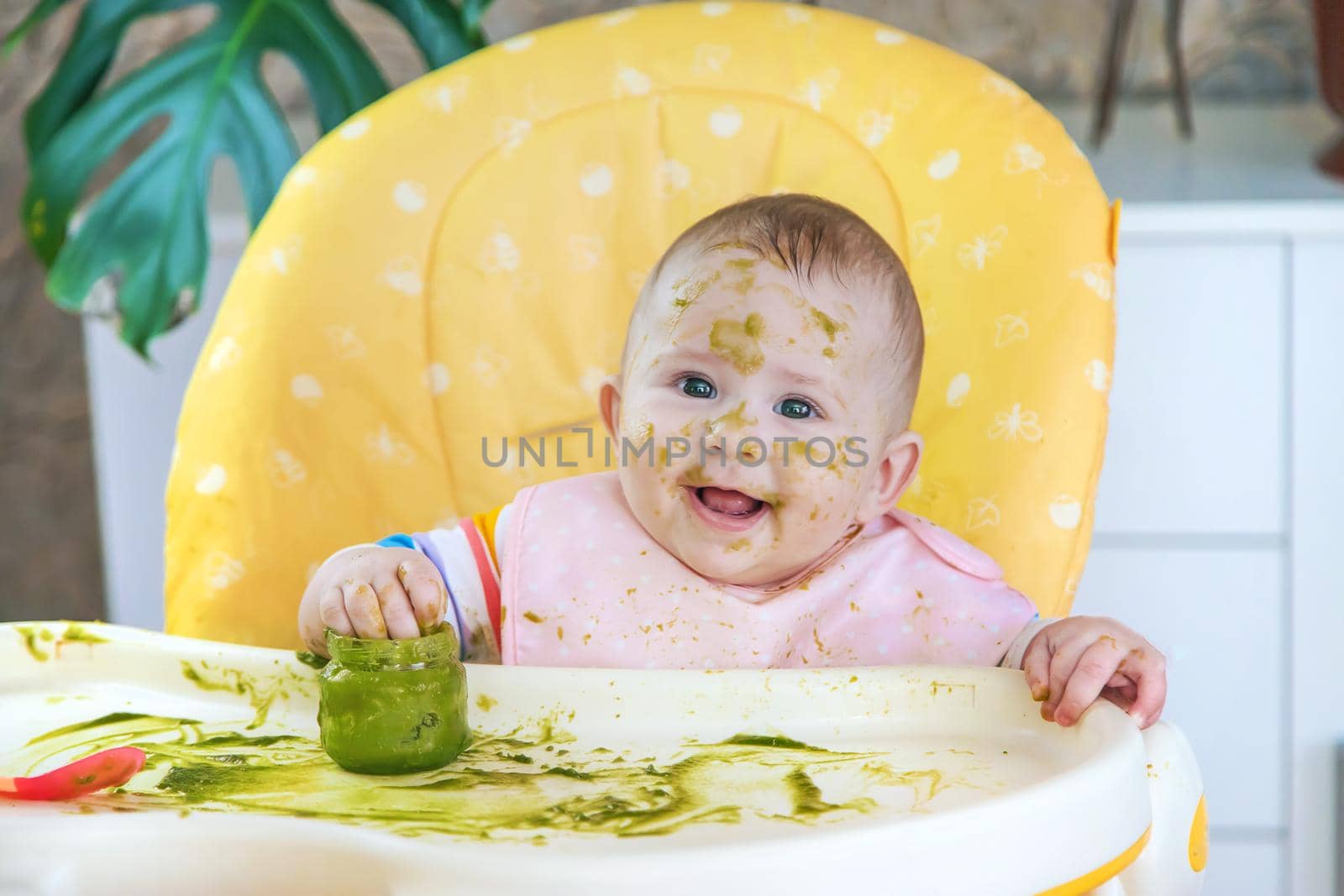 Little baby eats broccoli puree himself. Selective focus. by yanadjana