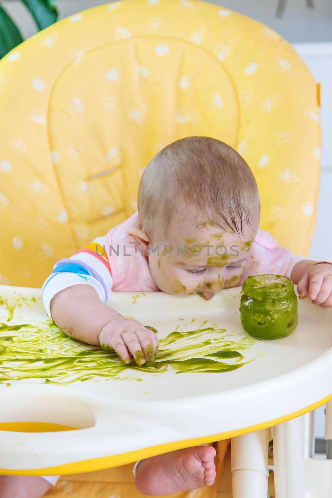 Little baby eats broccoli puree himself. Selective focus. by yanadjana