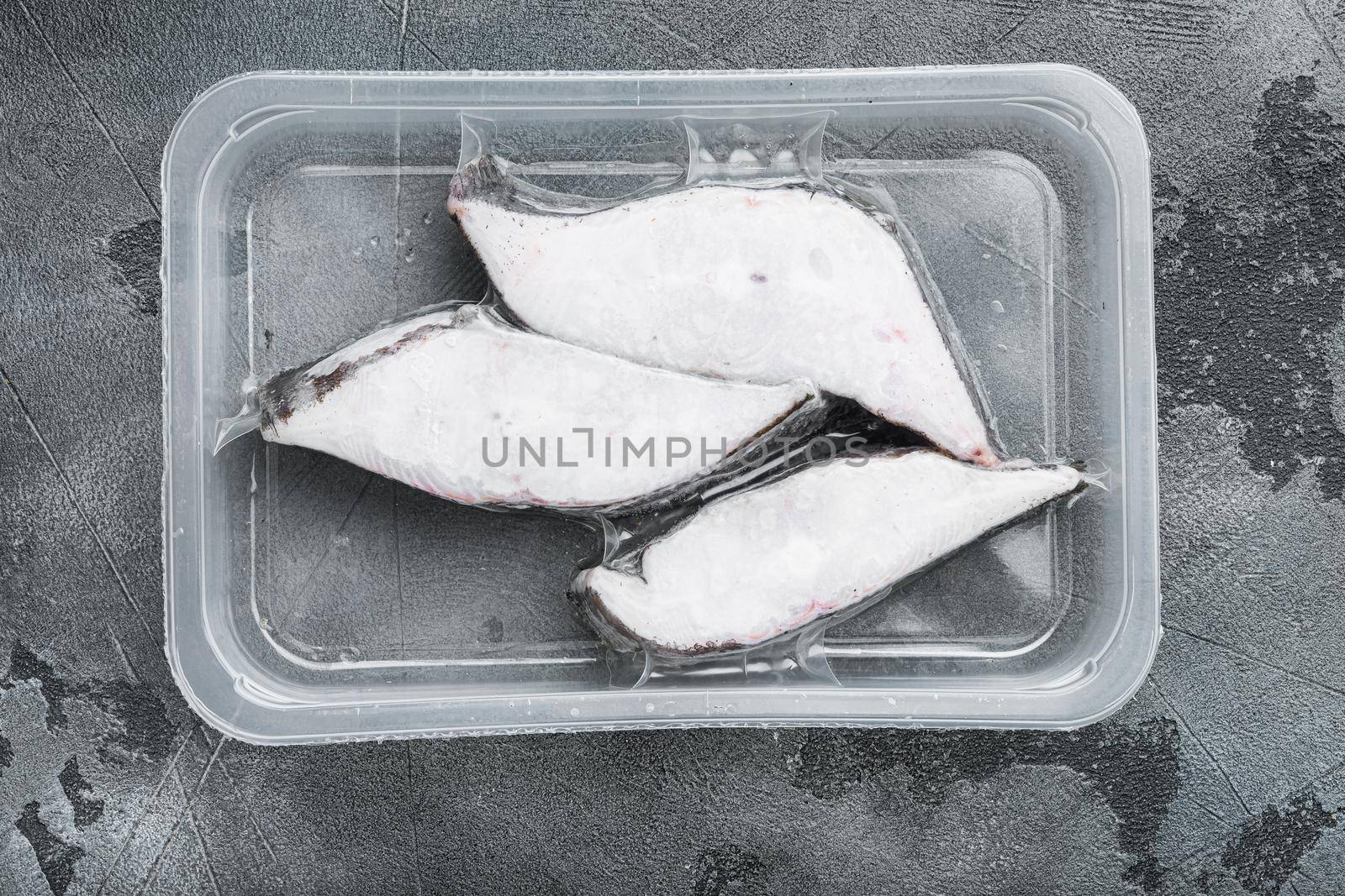 Halibut fish frozen steak pack set, on gray stone table background, top view flat lay