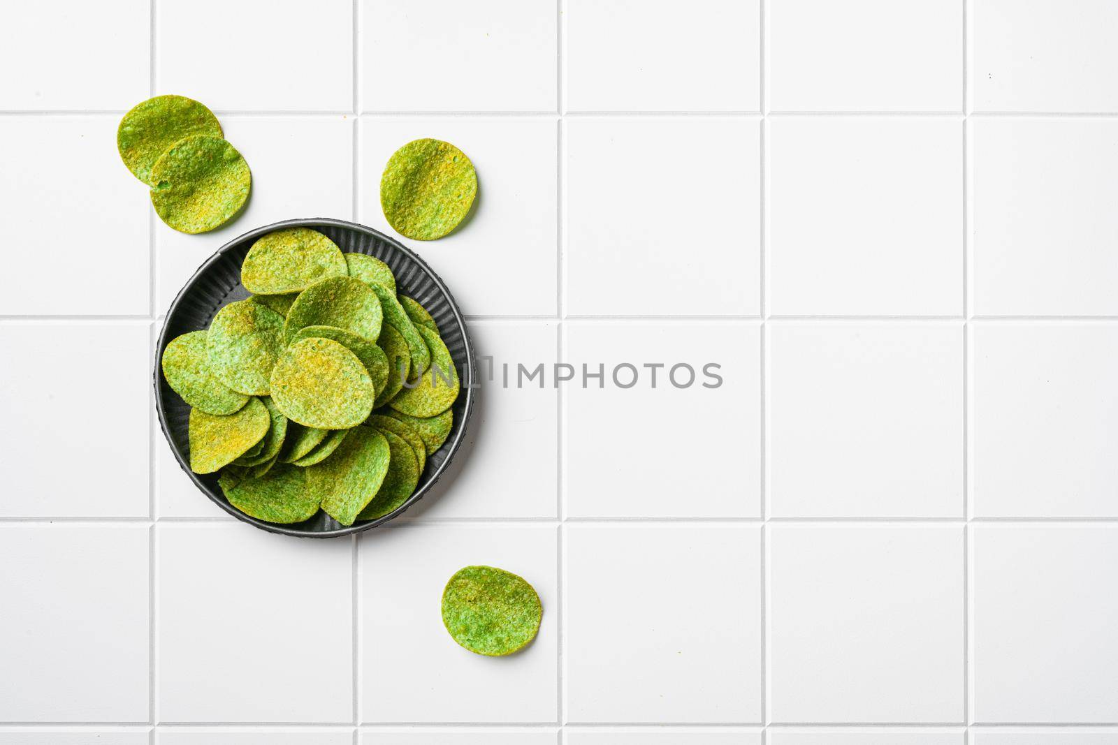 Green Chile Limon Flavored Potato Chips on white ceramic squared tile table background, top view flat lay, with copy space for text by Ilianesolenyi