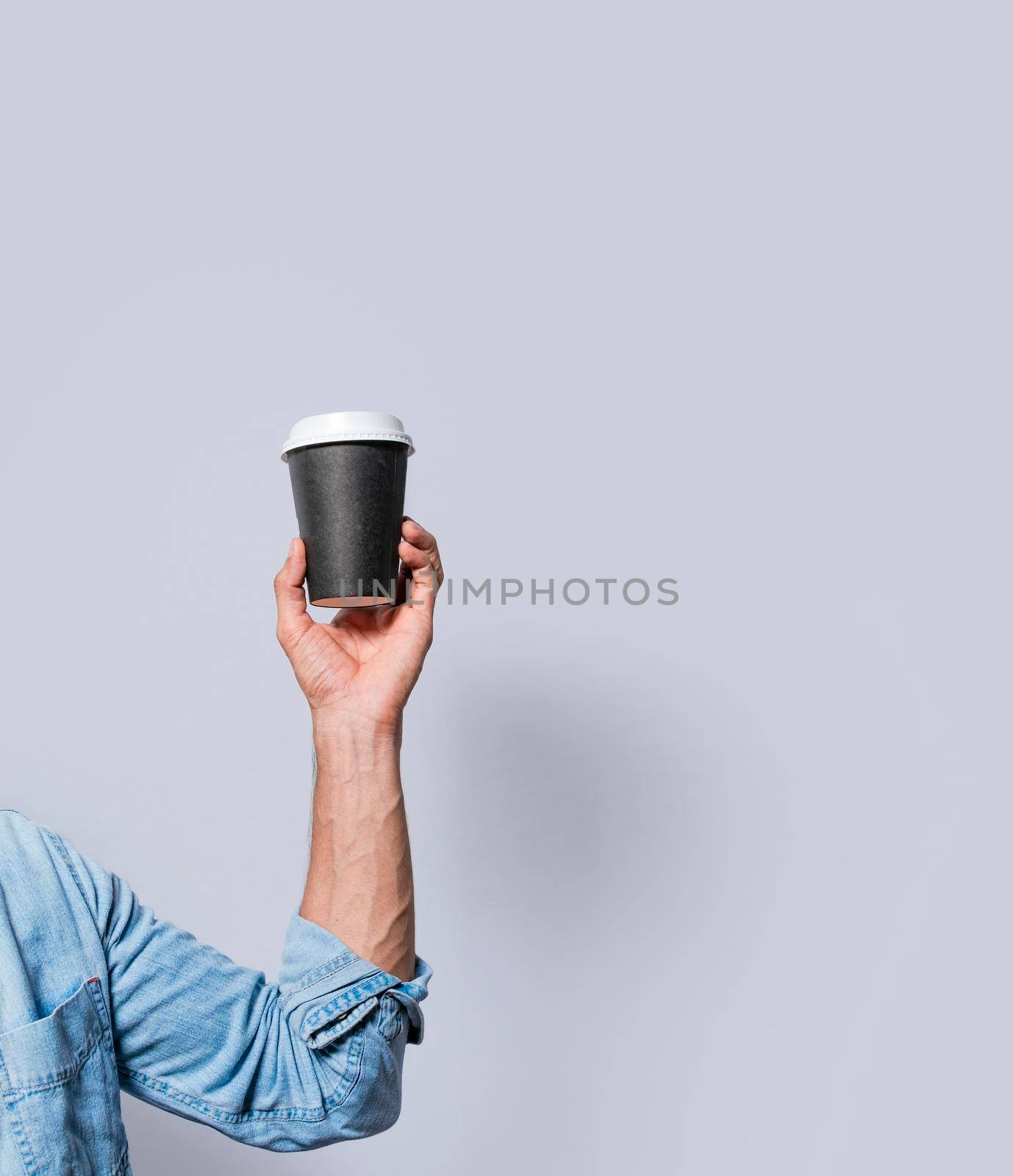 Close up of hand holding a paper cup of coffee. Hand holding a coffee to go on isolated background, Arm holding glass of coffee isolated by isaiphoto