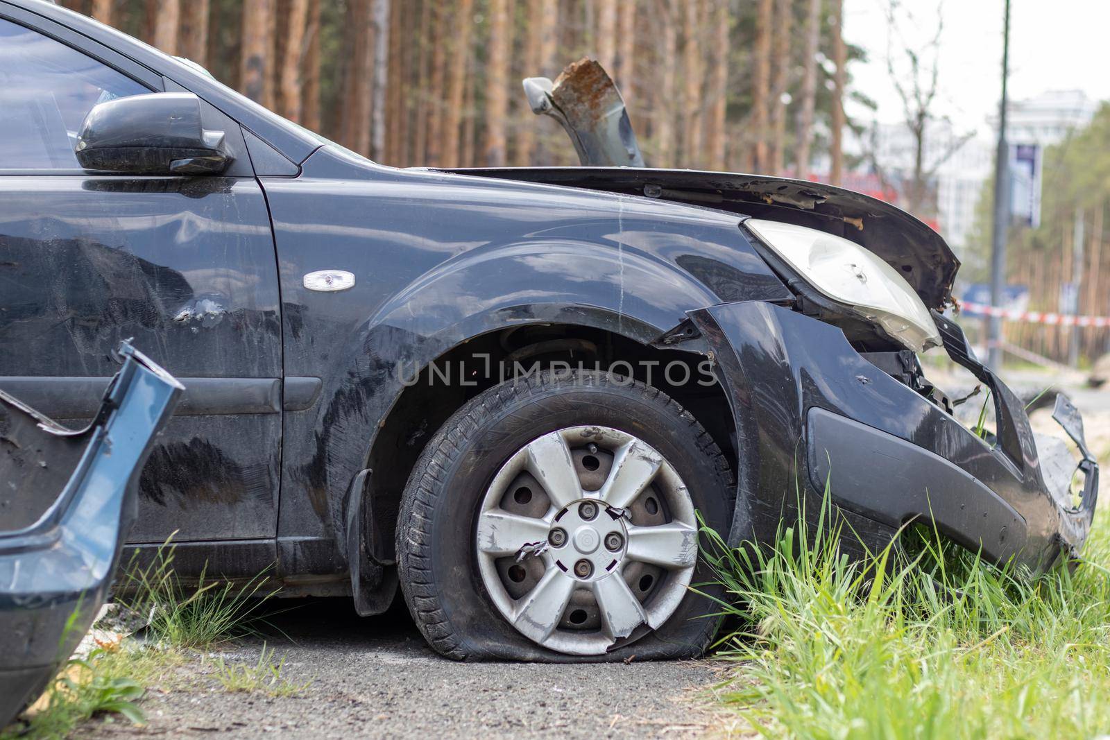 Black car after a terrible accident on the side of the road. Frontal and side impact. Life insurance. An accident without the possibility of recovery. Side view. Damage after an accident