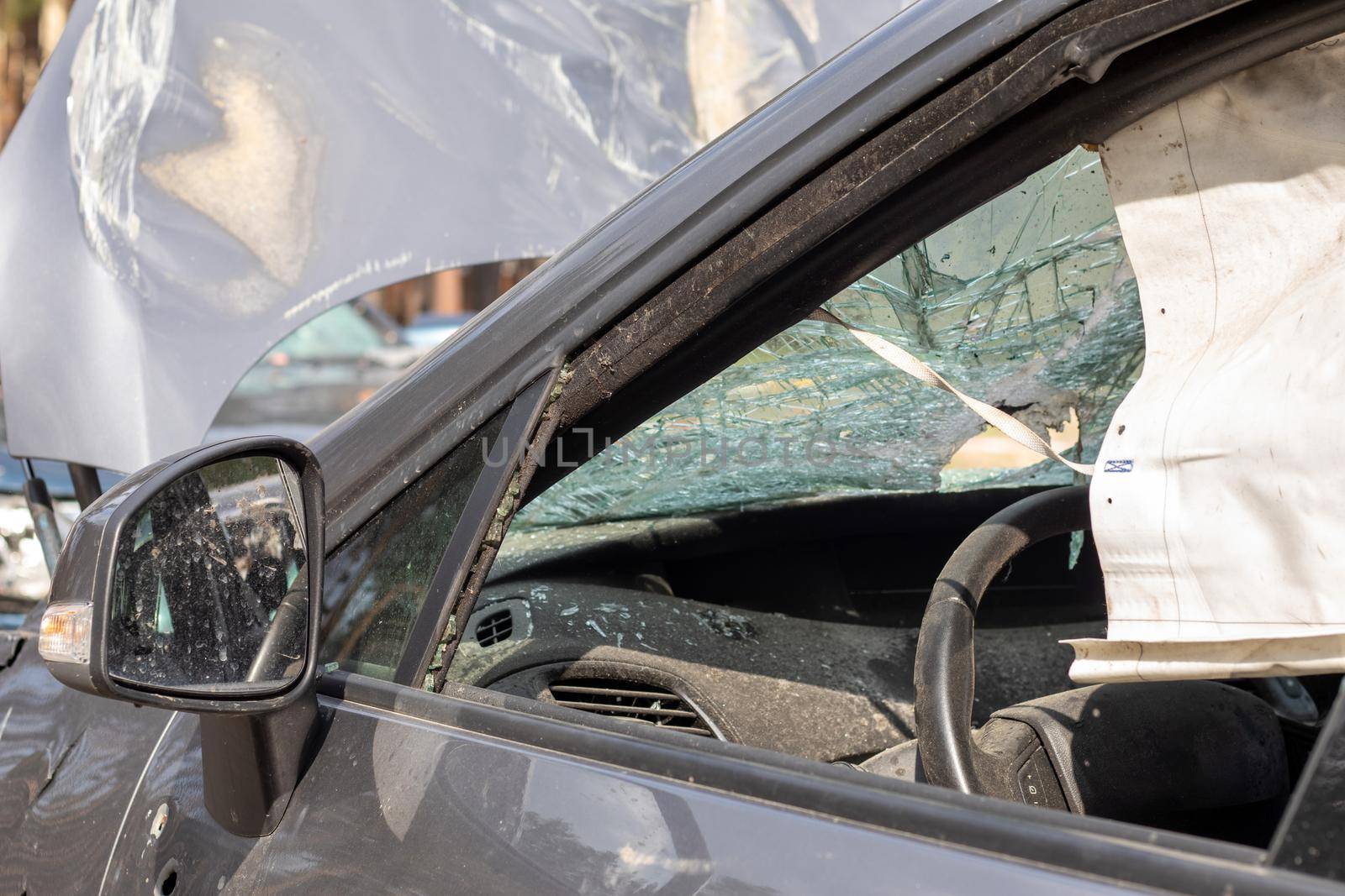 Shot car during the war in Ukraine. A car after an accident with a broken rear window. The wreckage of the interior of a modern car after an accident, a detailed close-up view of the damaged car
