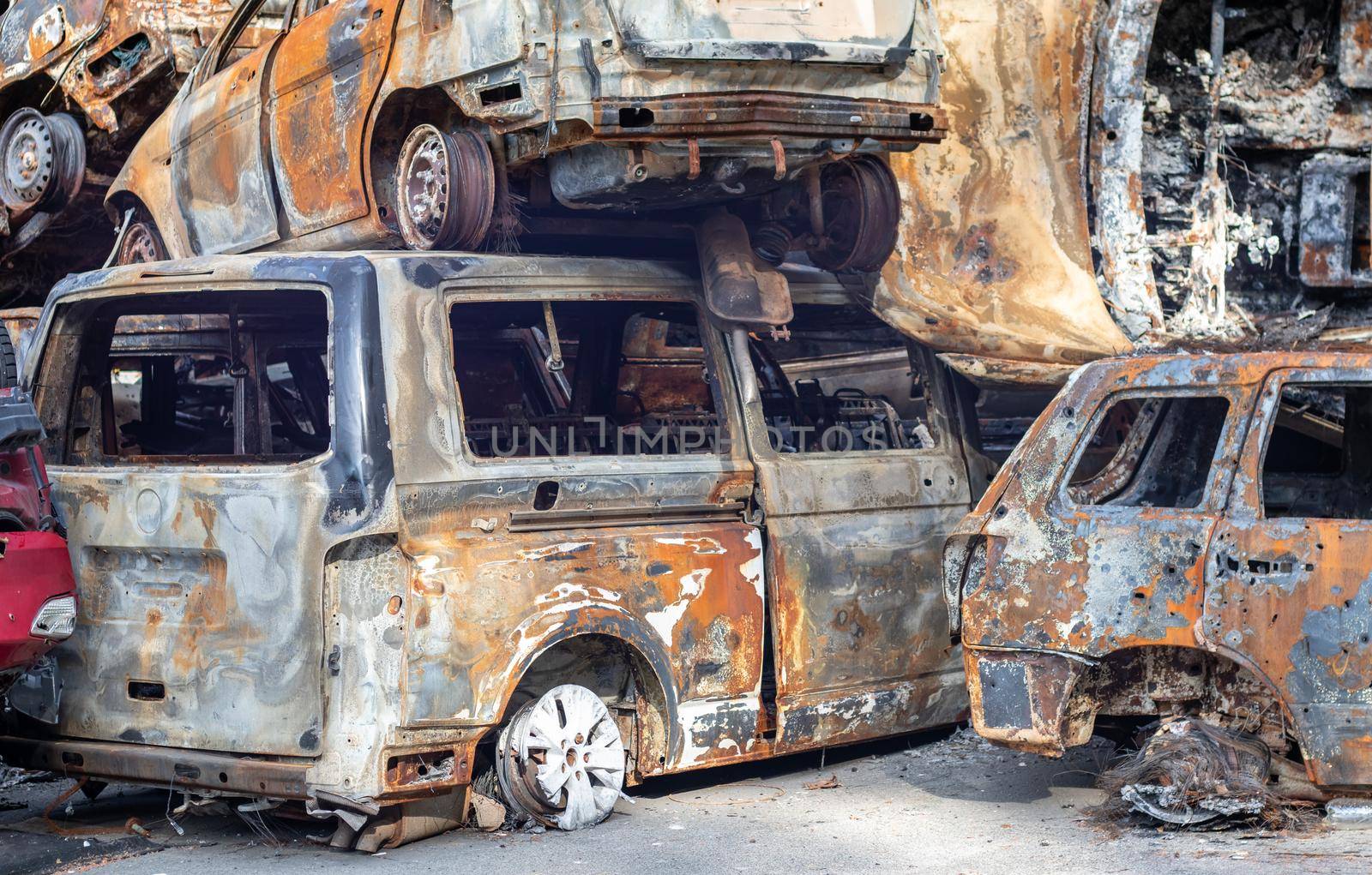 Rusty burnt cars destroyed by rocket explosions. War in Ukraine. Destroyed vehicles of civilians who were leaving were evacuated from the combat zone from Bucha and Irpin. Car graveyard