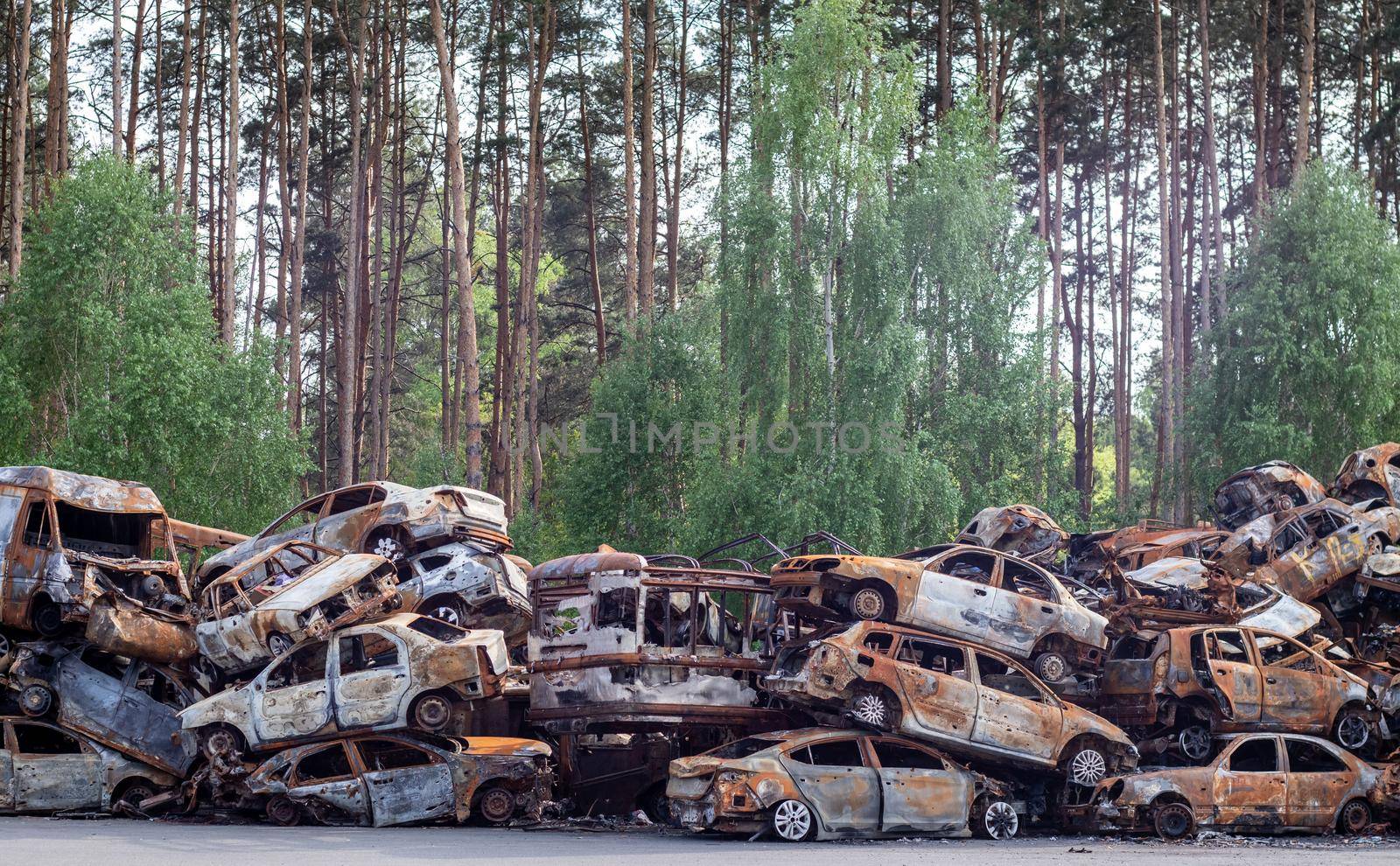 A lot of rusty burnt cars in Irpen, after being shot by the Russian military. Russia's war against Ukraine. Cemetery of destroyed cars of civilians who tried to evacuate from the war zone