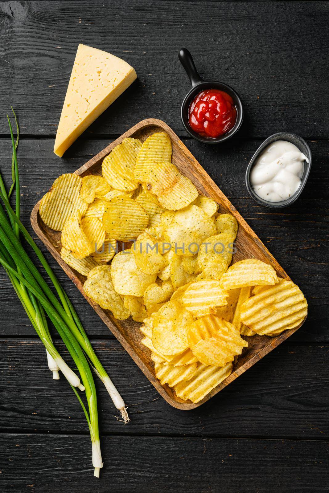 Set potato chips, on black wooden table background, top view flat lay