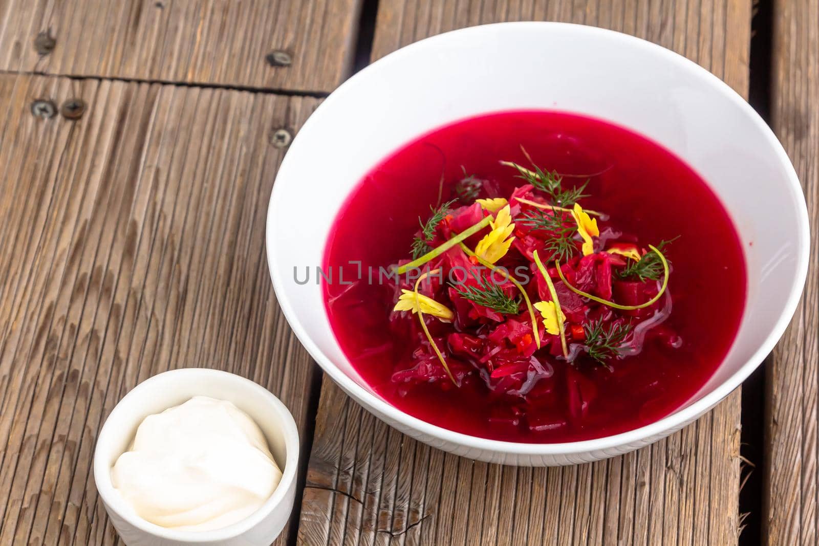 Vegetable cold soup with beet, cucumber, radsih and egg on wooden table by Milanchikov