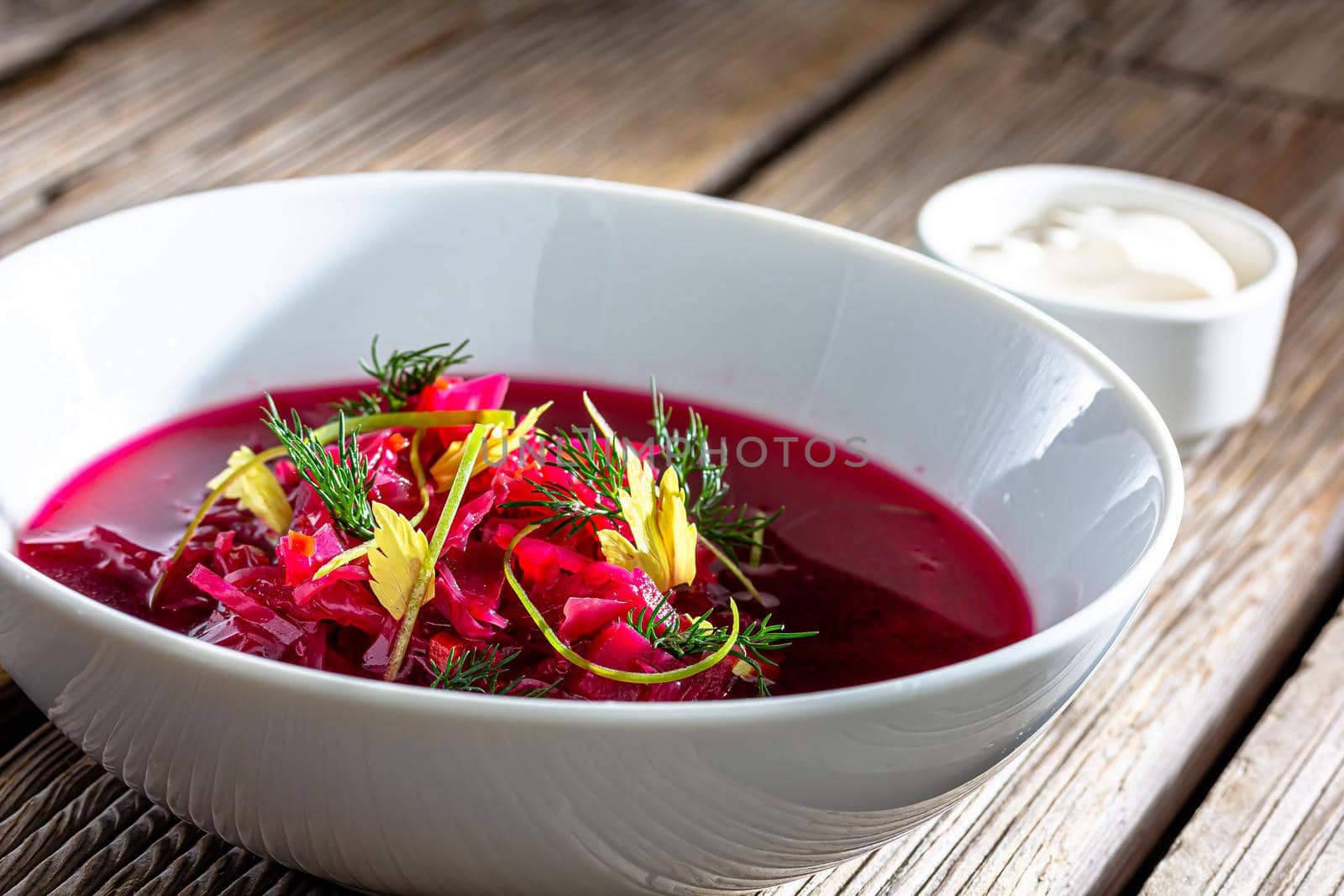Vegetable cold soup with beet, cucumber, radsih and egg on wooden table by Milanchikov