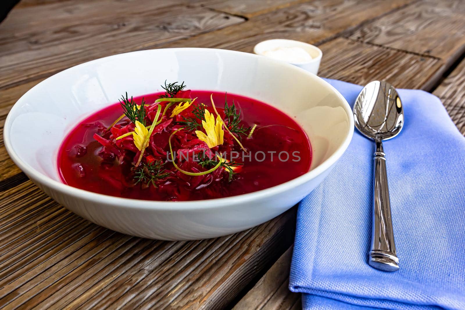 Vegetable cold soup with beet, cucumber, radsih and egg on wooden table.