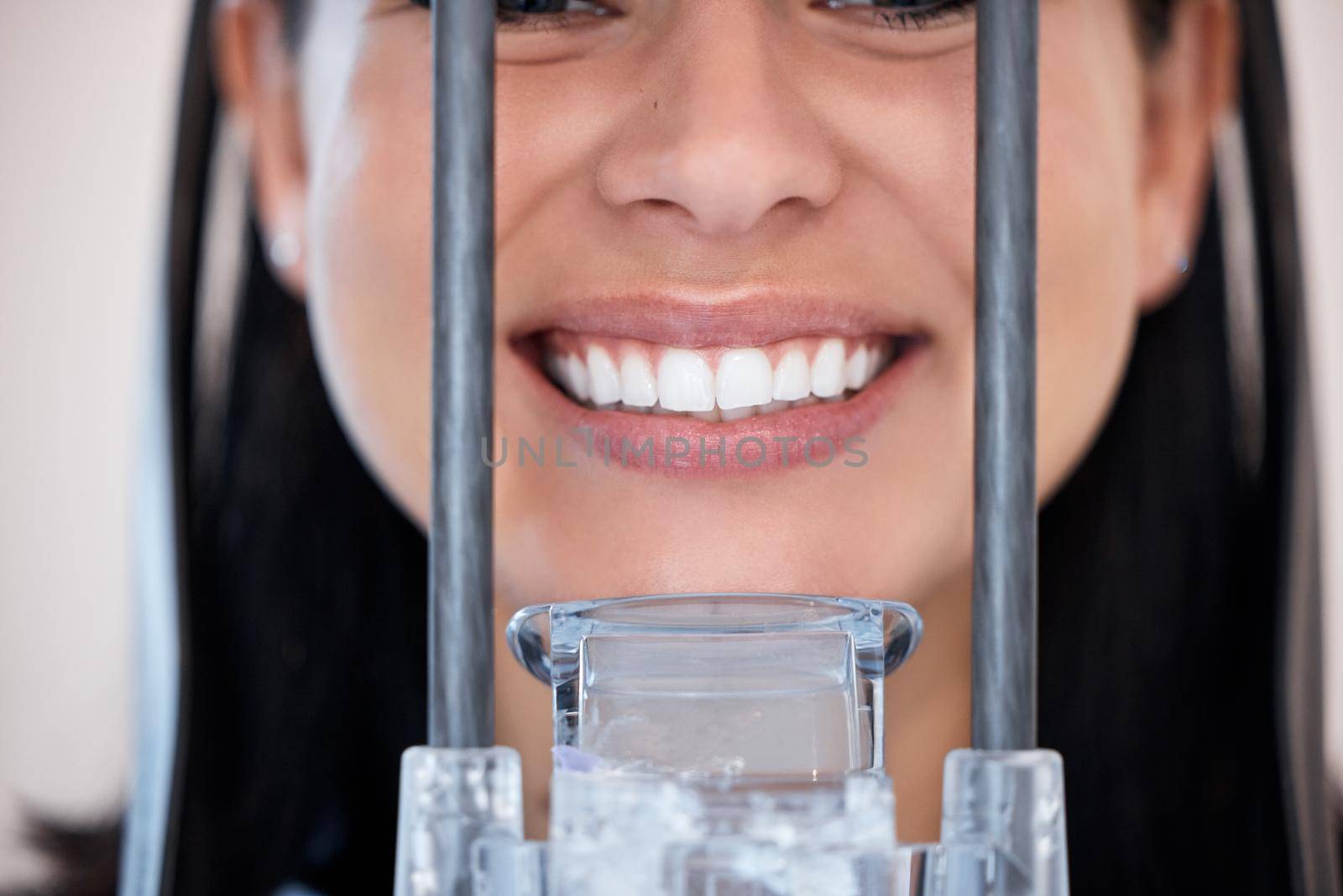 Closeup of a woman getting a digital x-ray scan of her mouth at the dentist. One female only smiling for a dental checkup. Patient taking care of her oral hygiene to maintain healthy teeth and gums.