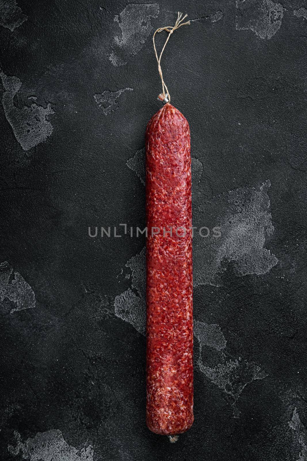 Whole sausage salami set, on black dark stone background, top view flat lay, with copy space for text
