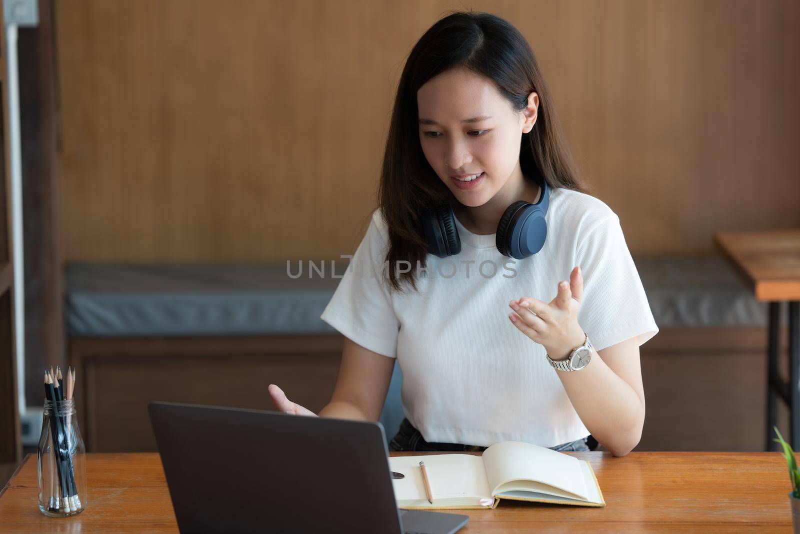 Image of Young woman with a headset working online on laptop computer. studying or working from home online concept