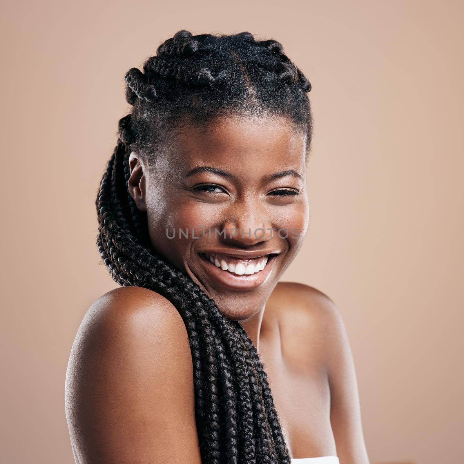 I wear my braids like a crown. Cropped portrait of an attractive young woman posing in studio against a brown background. by YuriArcurs