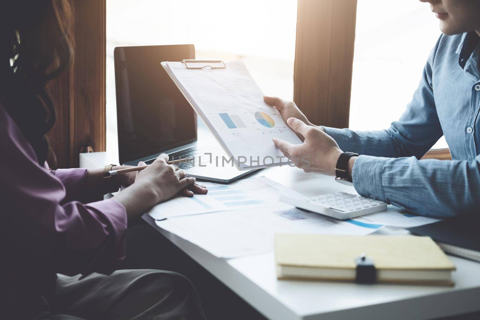 teamwork concept, consulting, portrait of male economist holding budget papers finance and investment Discuss and plan finances with a female marketer adviser in the conference room by Manastrong