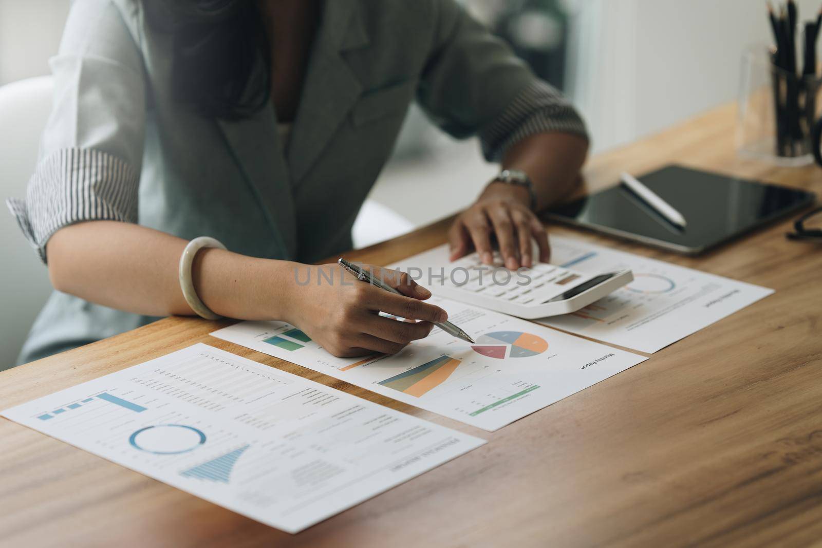 Close up Business woman hand using calculator to calculate the company's financial results and budget. Account Audit Concept