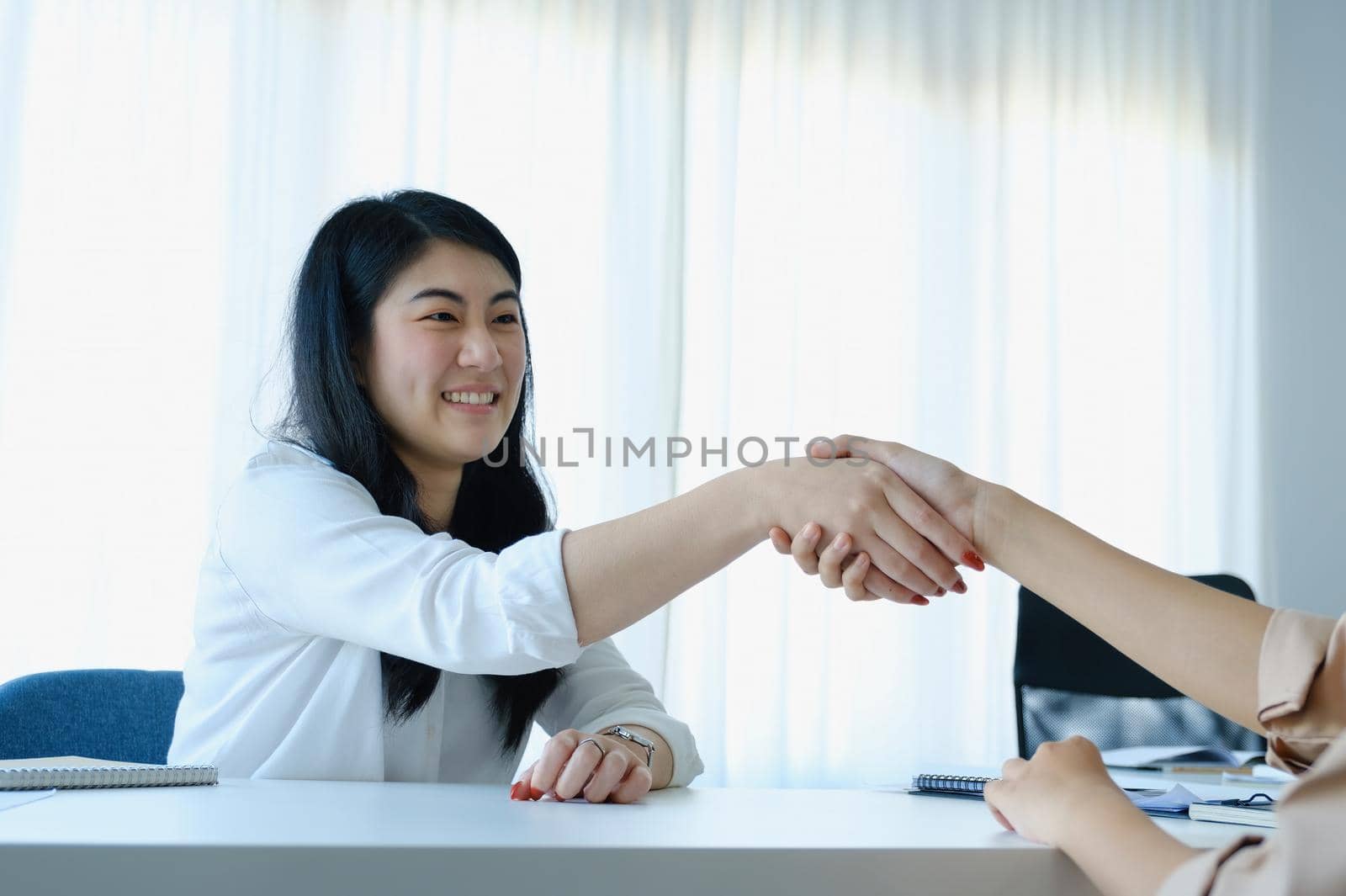 Young businesswoman collaborate with partners to increase their business investment network for Plans to improve quality next month in their office. agreement concept. by Manastrong