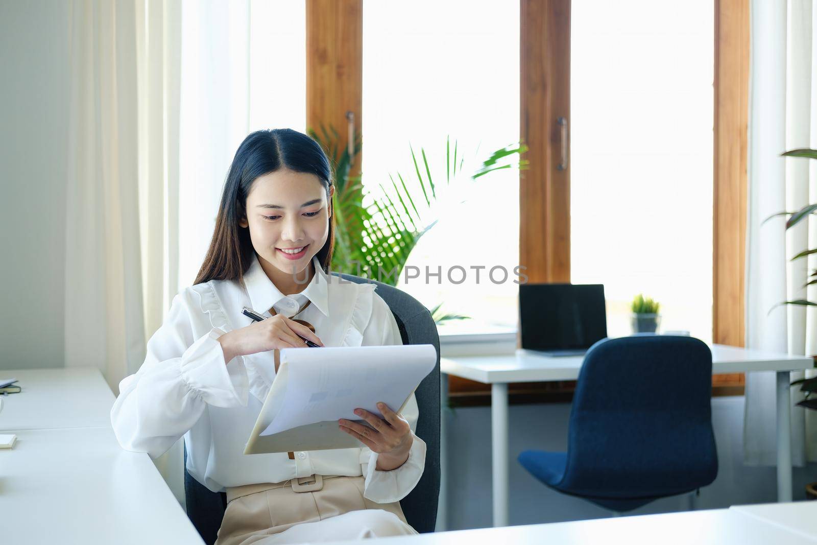 Young economists or accountants or financiers and investors are reviewing budget documents and using computers to study impact and risk assessments on corporate investment management