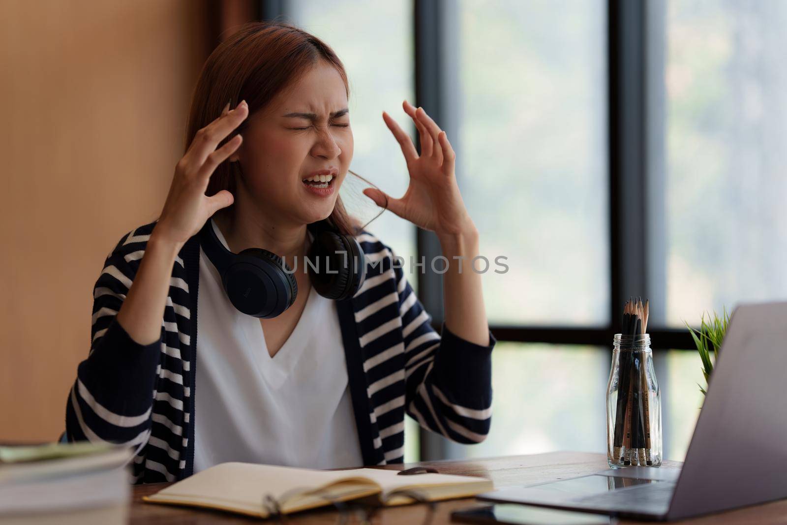 Image of Asian Business woman stressed and screaming after end of video conference at home. Expression and Emotional concept