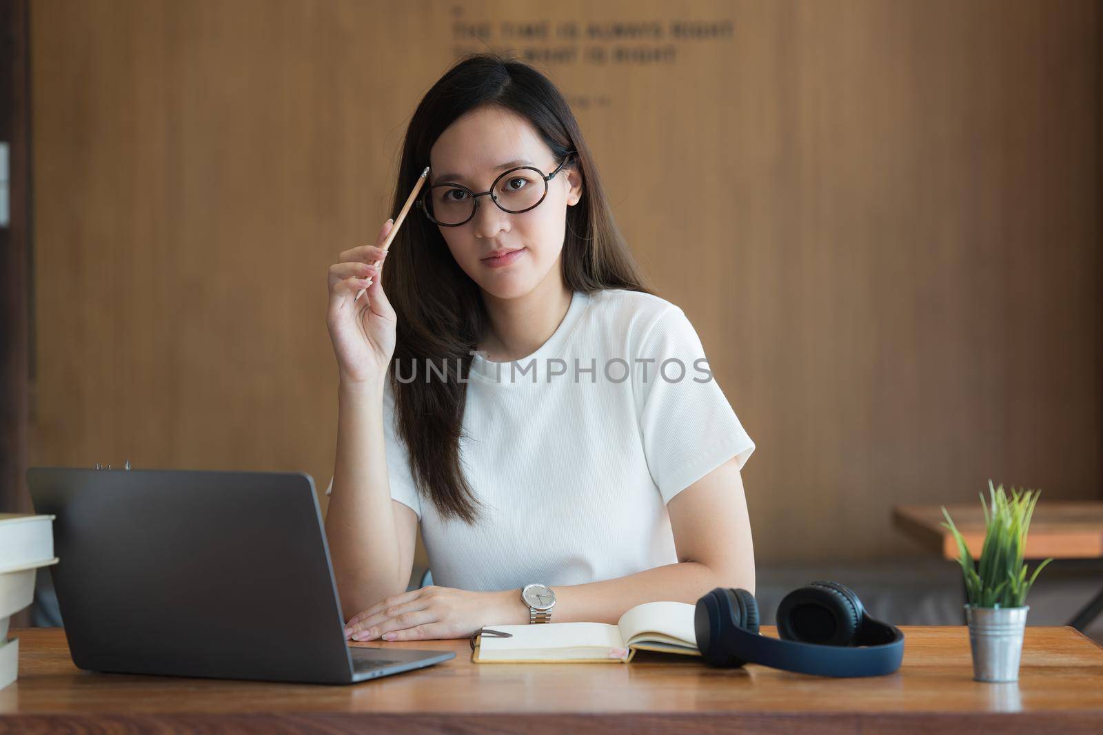 Image of Young woman with a headset working online on laptop computer. studying or working from home online concept