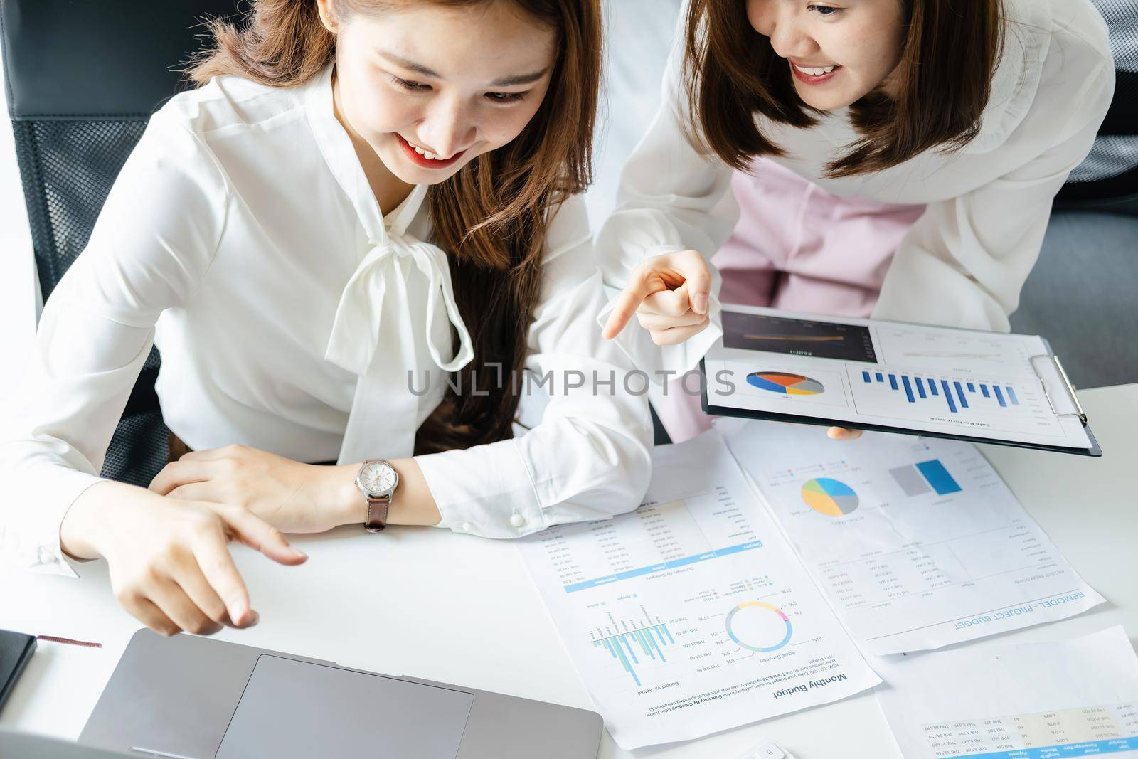 Negotiation, Analysis, Discussion, Asian woman economist and marketer using computer laptop to plan investments and financial to prevent risks and losses for the company.