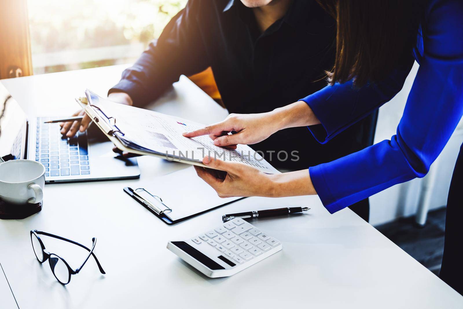 Teamwork concept, consultation, female advisor pointing to budget, finance and investment papers, discussing and planning finances with male economists in conference room. by Manastrong