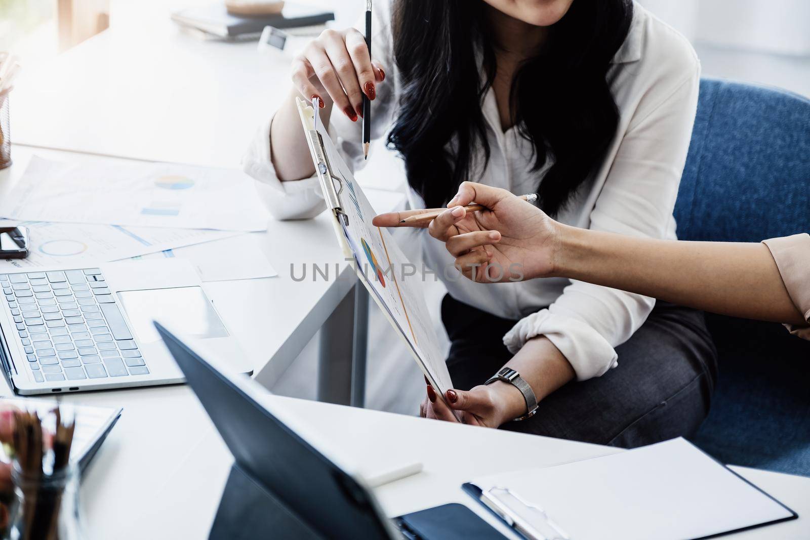 Negotiation, Analysis, Discussion: Portrait of an Asian woman economist and marketer pointing to a financial data sheet to plan investments to prevent risks and losses for the company.