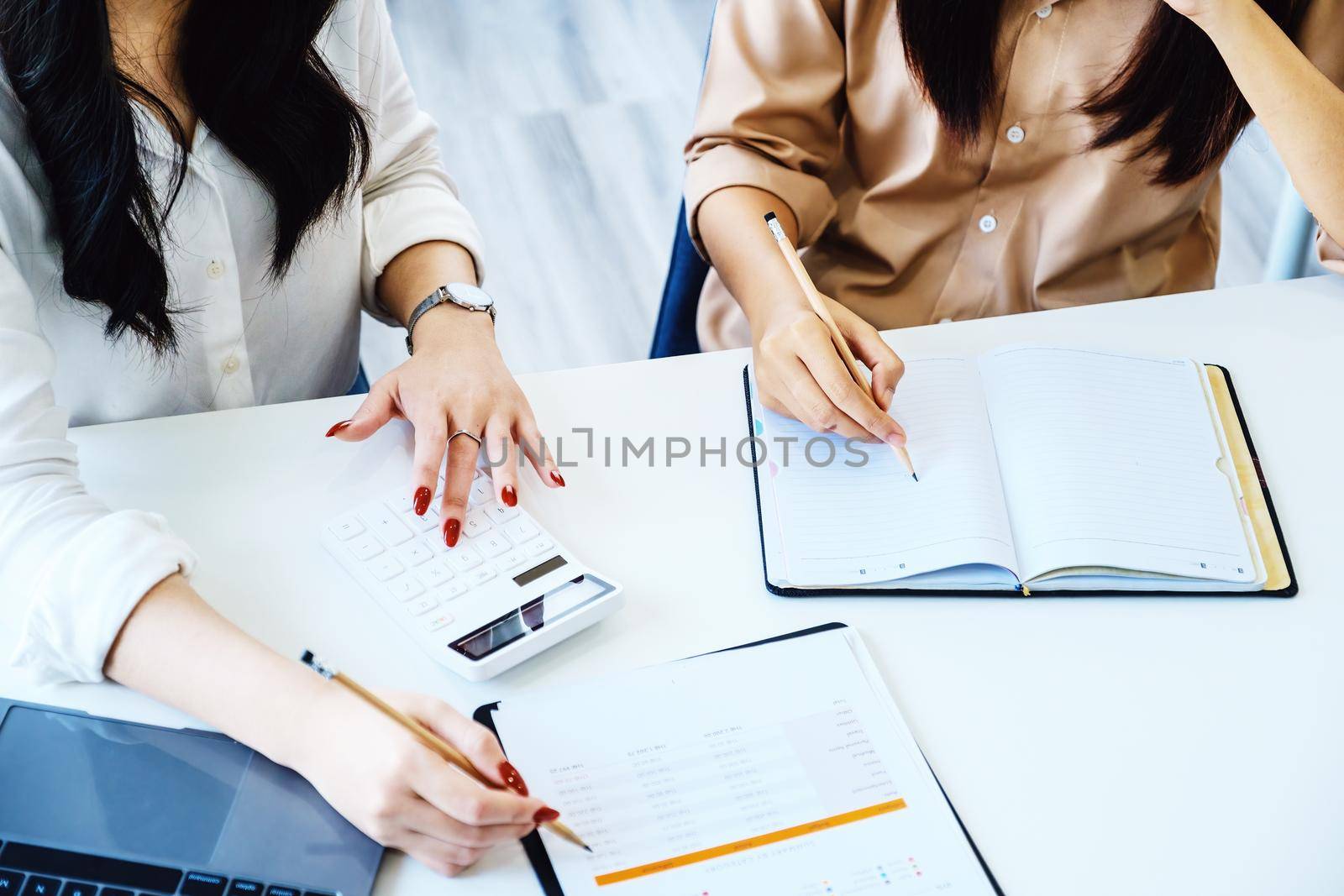 Negotiation, Analysis, Discussion, Asian woman economist and marketer pointing to a financial data sheet to plan investments to prevent risks and losses for the company by Manastrong