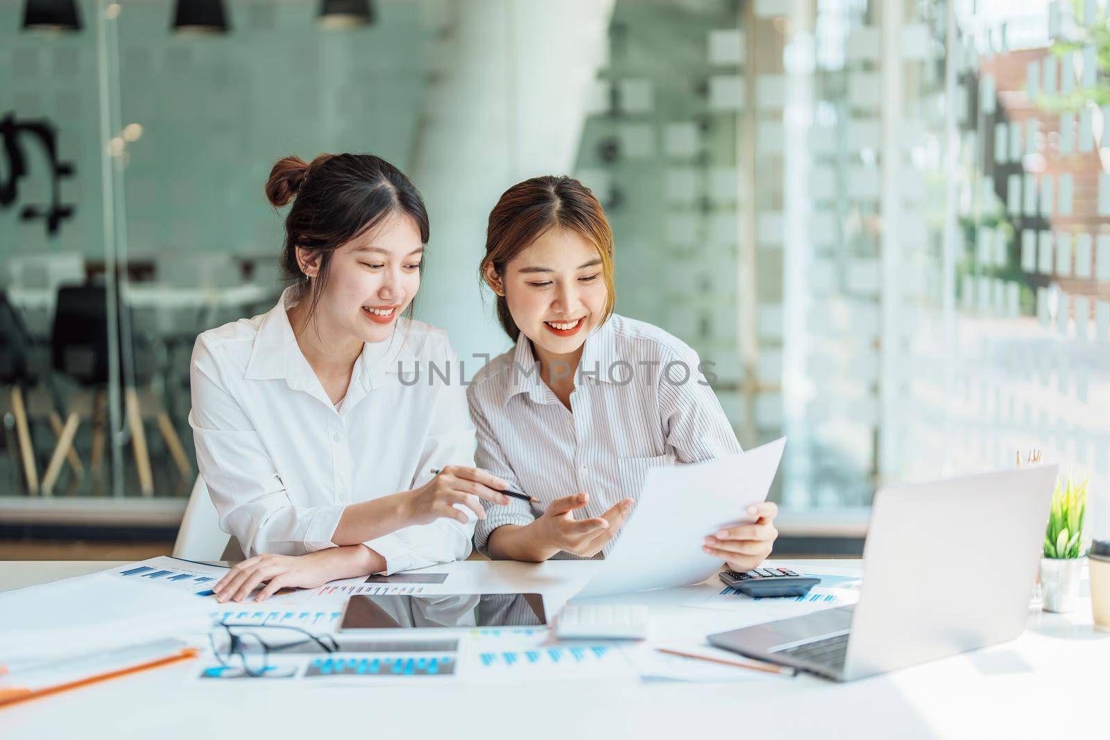 Negotiation, Analysis, Discussion: Portrait of an Asian woman economist and marketer pointing to a financial data sheet to plan investments to prevent risks and losses for the company.