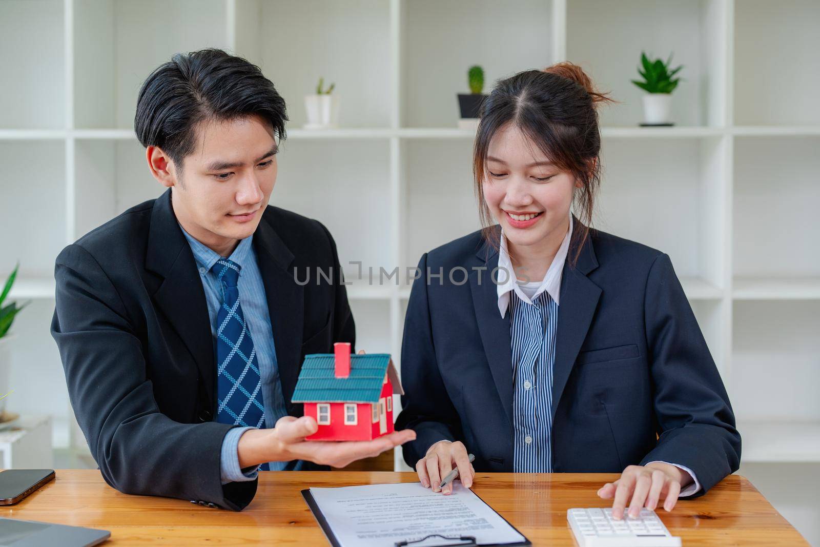 Guarantees, mortgages, signing, interest on loans, real estate agents are making agreements with customers to buy houses and land and sign contract documents.