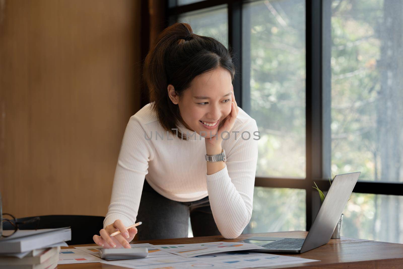 Consult financial concept. Business woman pointing at paperwork and using calculator on desk at office. back to office