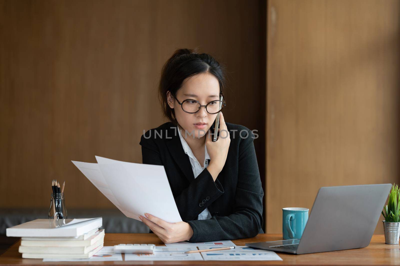 Image of Young woman with a cell phone working online on laptop computer. studying or working from home online concept