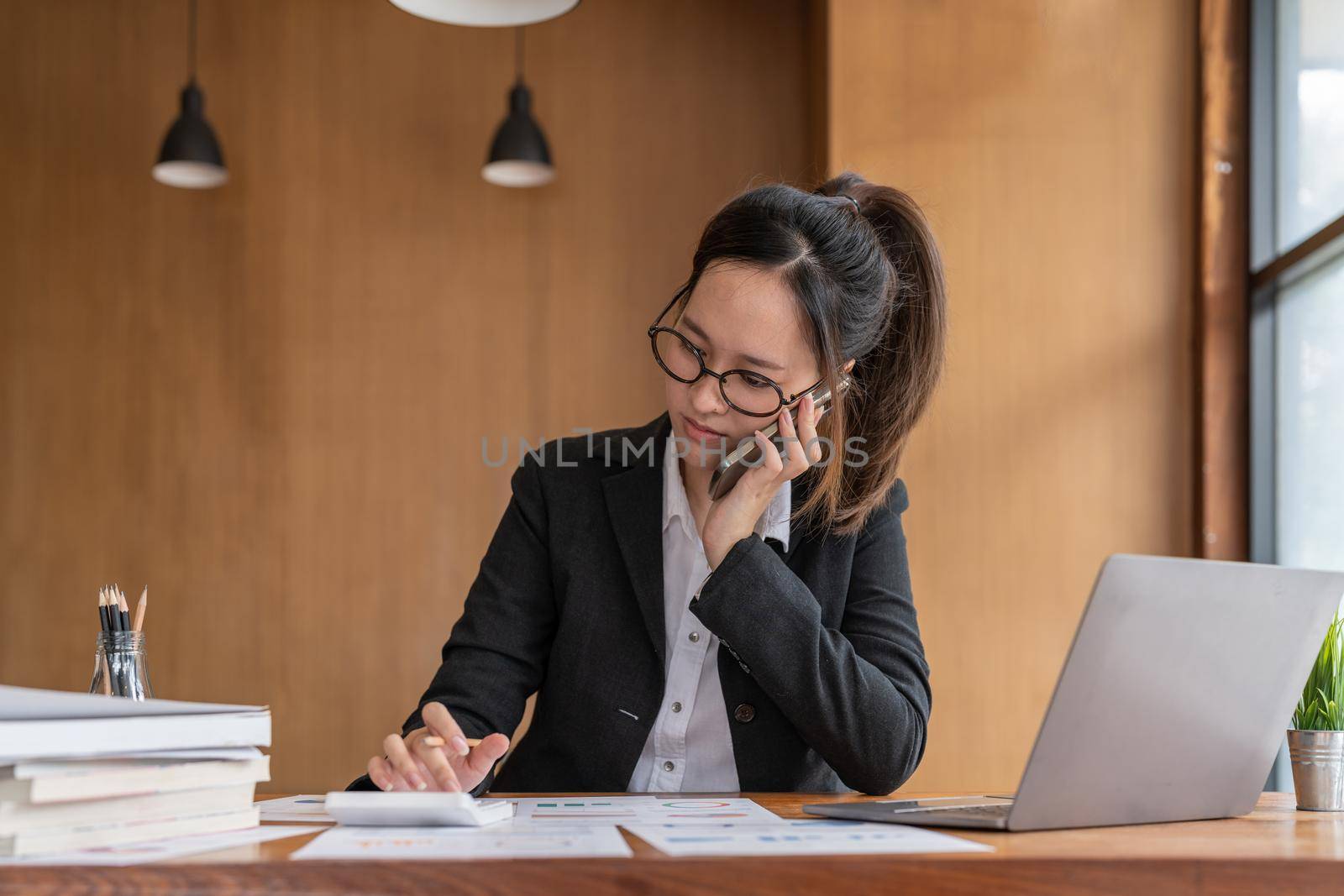 Busy business accountant woman making call phone in office and business working background, tax, accounting, statistics and analytic research concept.