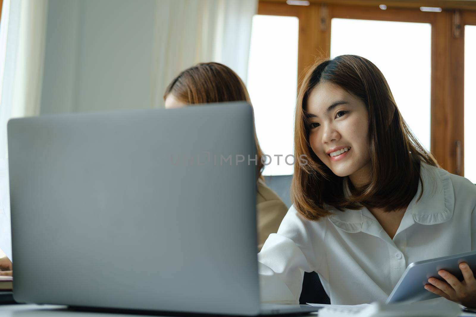 Negotiation, Analysis, Discussion, Portrait of an Asian woman economist and marketer using computer laptop to plan investments and financial to prevent risks and losses for the company.