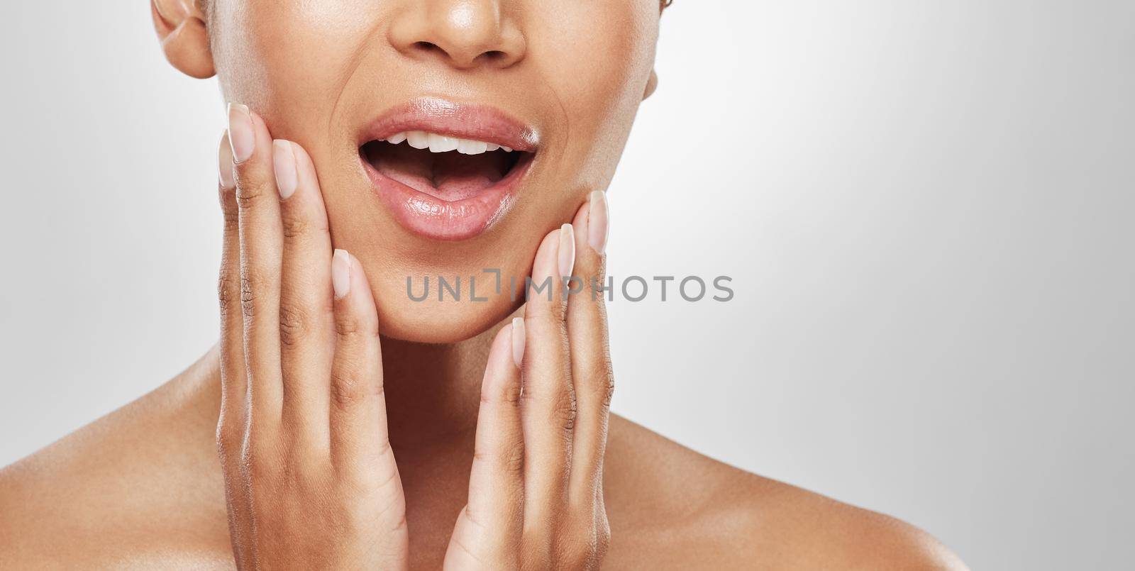 In desperate need of the dentist. Studio shot of an unrecognisable woman experiencing toothache against a grey background. by YuriArcurs