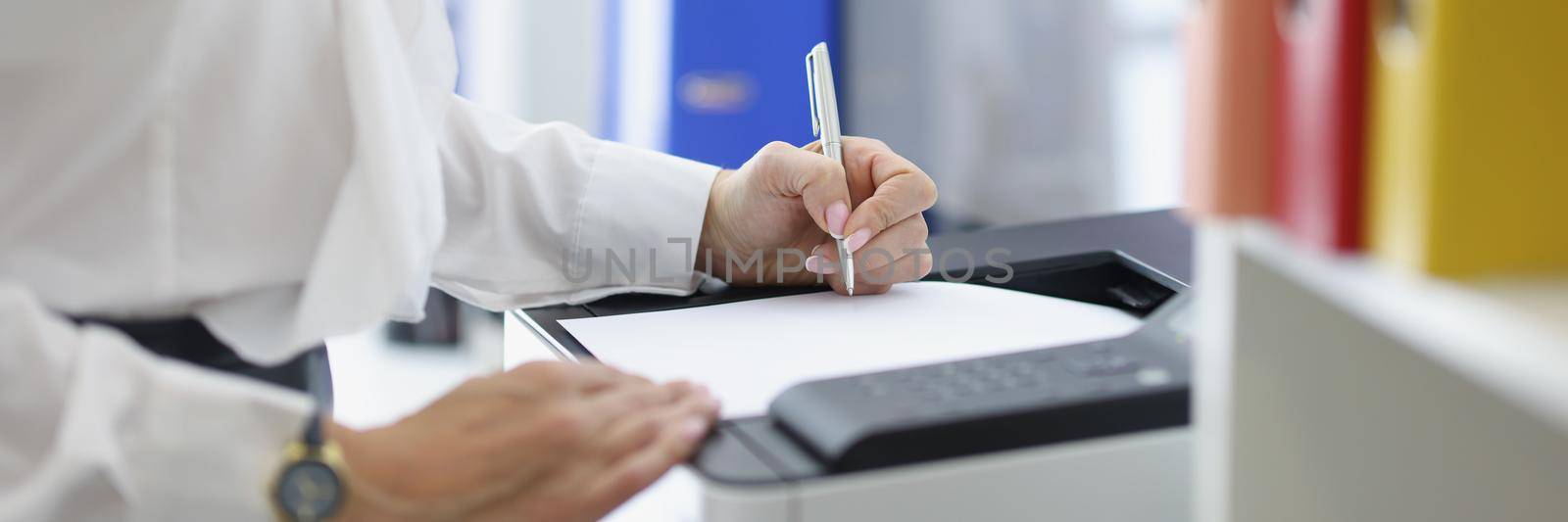 Close-up of female secretary or office worker print papers on printer machine. Company employee in suit fill document on device. Office life, job concept