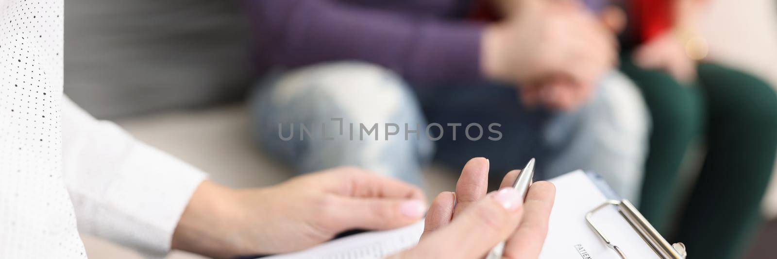 Close-up of doctor hold clipboard with patient medical history paper for couple. Qualified worker examine ask questions clients. Medicine, clinic concept