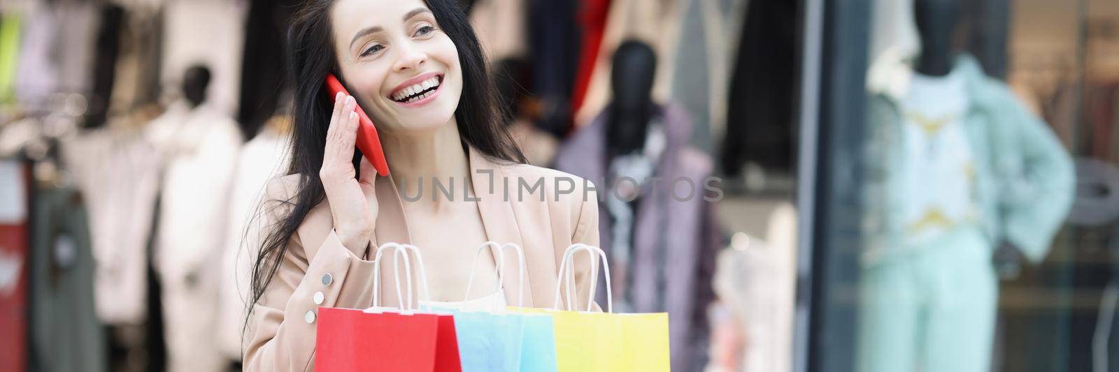 Young woman shopaholic smiling and tell to friend on call about sales by kuprevich
