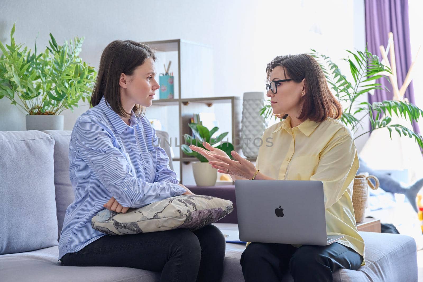 Young woman patient on individual therapy in psychologists office. Mature female counselor listening taking notes talking. Psychology, psychiatry, treatment, mental health concept