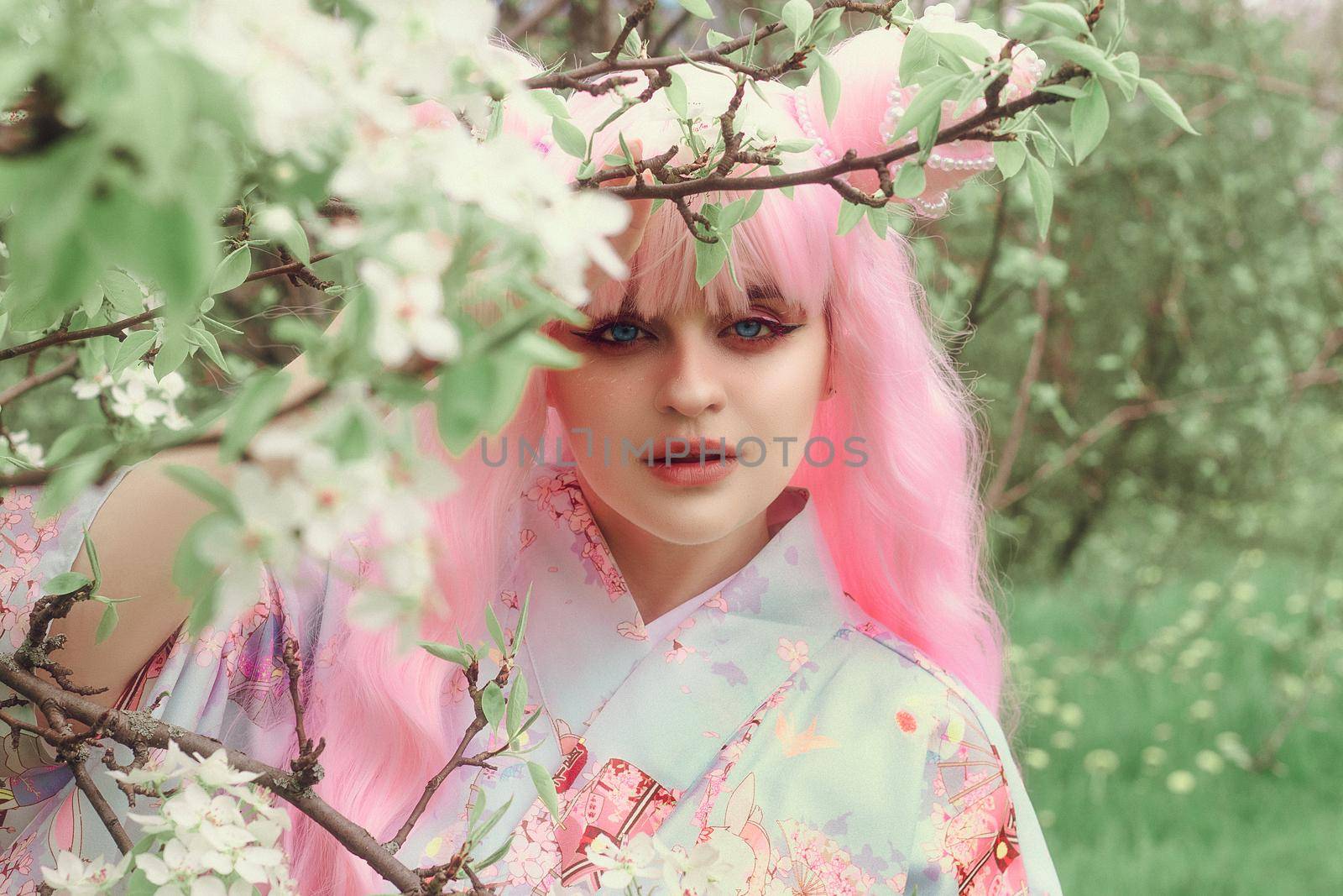 Portrait of young european woman wearing kimono. Asian beauty. Cherry blossoms. Hanami. Sightseeing of Japan concept.