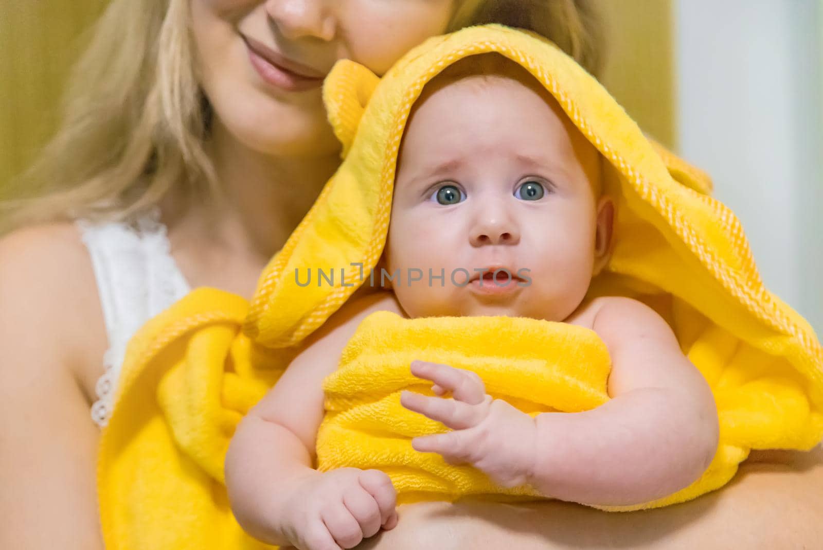 Baby after bathing in a towel. Selective focus. People.