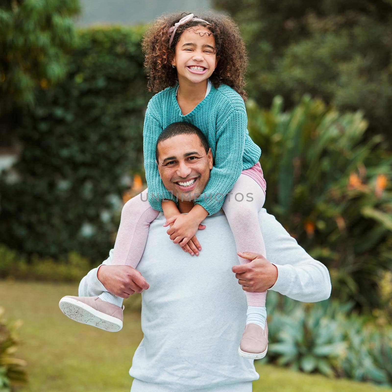 Shot of a man carrying his daughter on his shoulders.