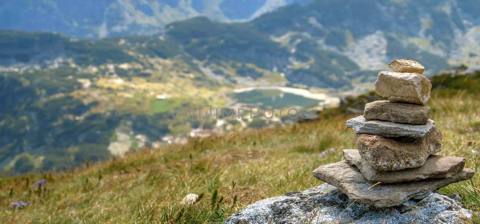 Balancing pebbles from mountain stones stack.  Panoramic view. Blurred background