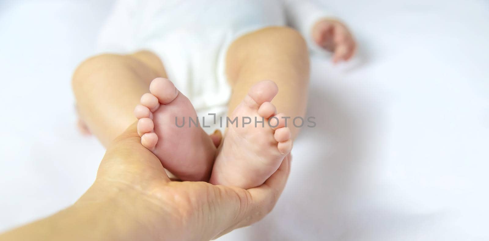 Mom holds the baby's legs. Selective focus. by yanadjana