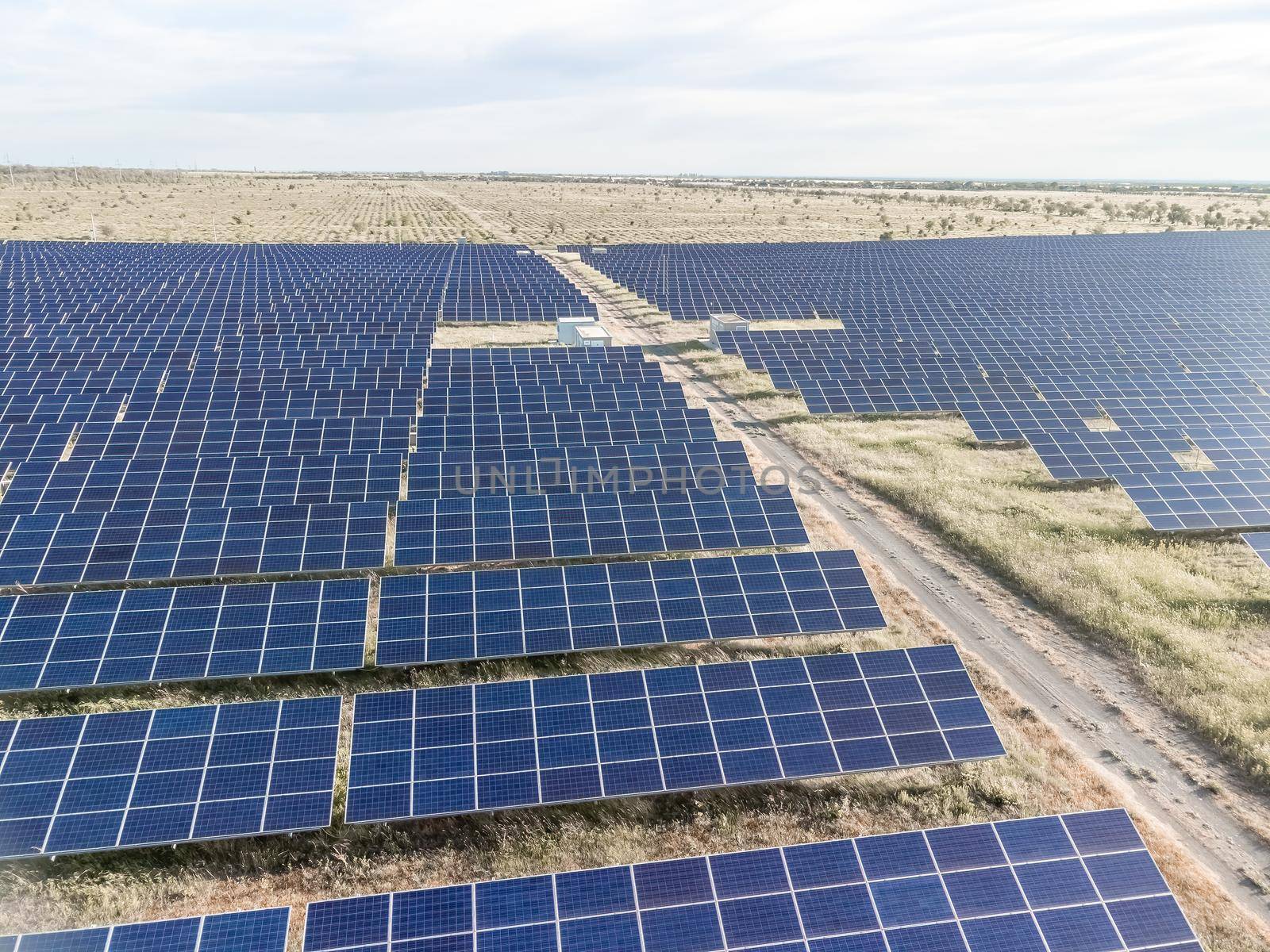 Aerial top view of a solar panels power plant. Photovoltaic solar panels at sunrise and sunset in countryside from above. Modern technology, climate care, earth saving, renewable energy concept