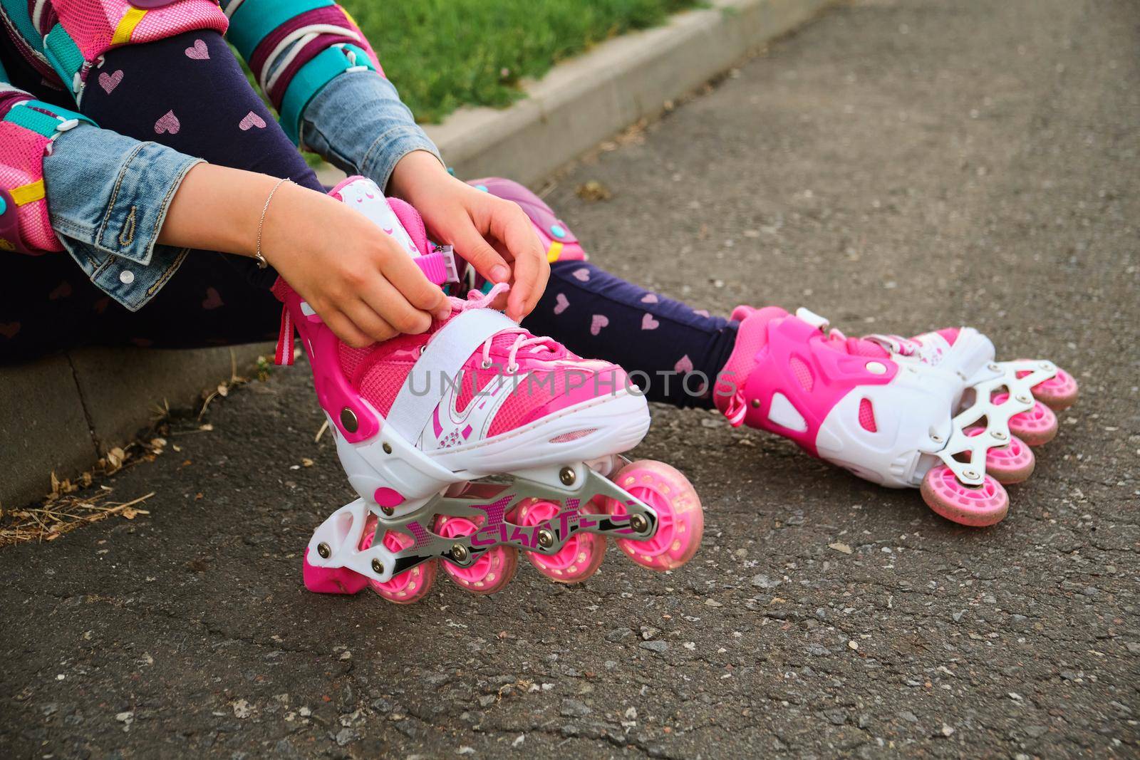 little girl learning to roller skate outdoor. Child enjoying roller skating ride outdoors. Close-up Of Legs Wearing Roller Skating Shoe, Outdoors