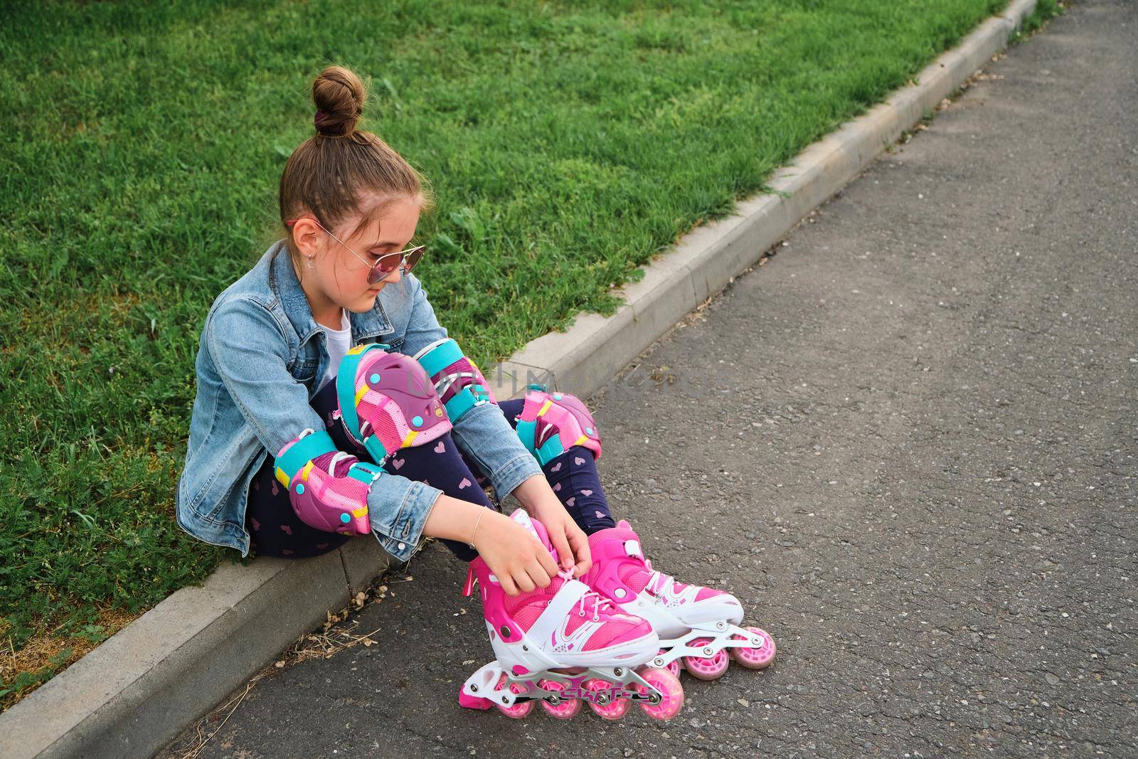 Pretty little girl learning to roller skate on beautiful summer day in a park. Child wearing Wearing Roller Skating Shoe, Outdoors