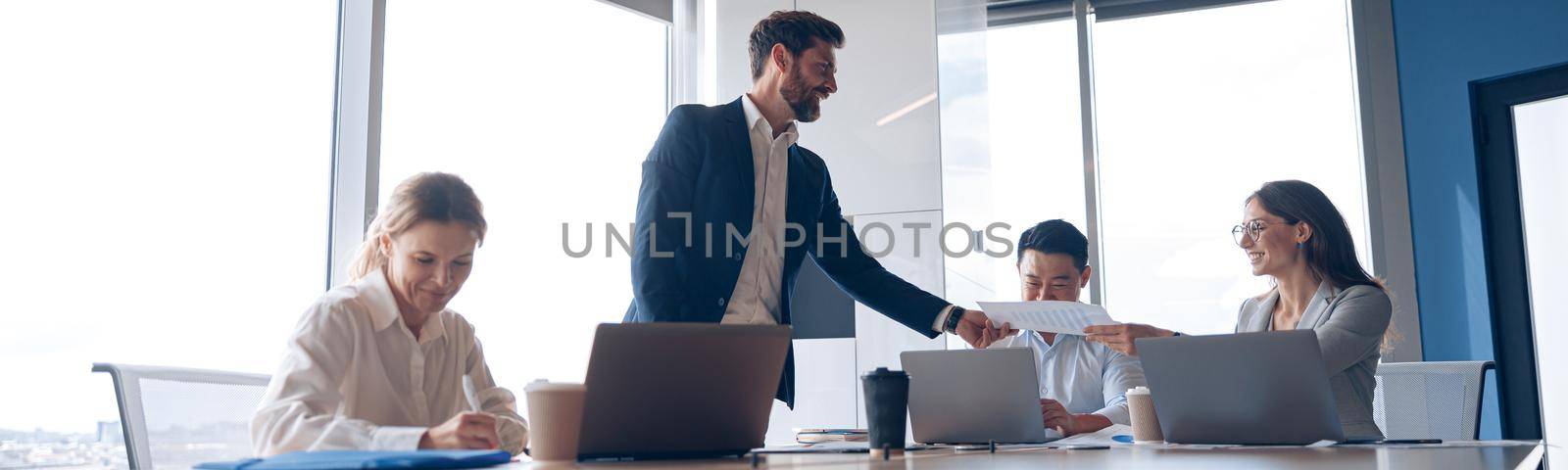 Creative business team working on new project in modern office with panoramic view. Teamwork concept