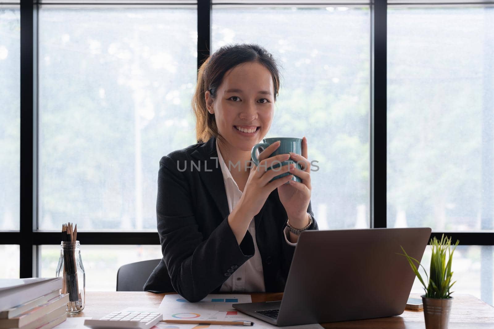 Business accountant woman using calculator with computer laptop, Business accounting, budget and loan paper in office