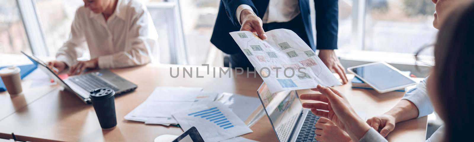 Close up of business people consider documents with charts in a modern office. Teamwork concept