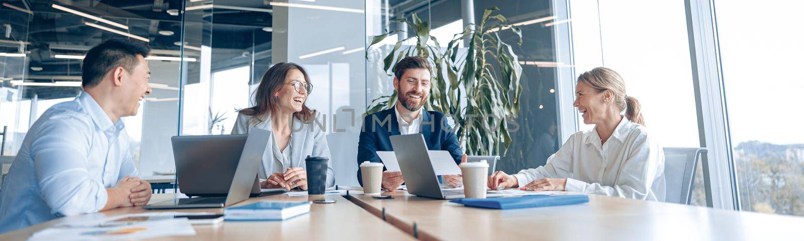 Creative business people working on project in modern office with panoramic view by Yaroslav_astakhov